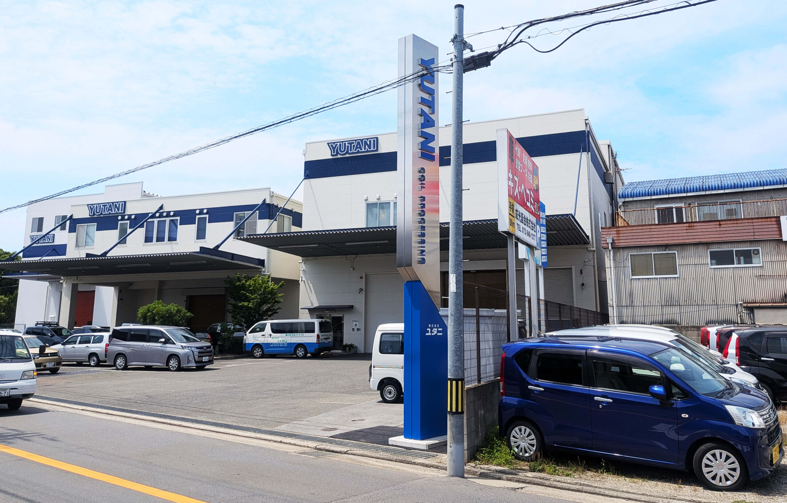 株式会社ユタニ様の新工場とコーポレートタワーサインを一緒に撮影した写真